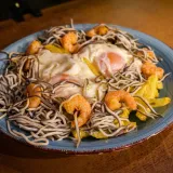 Deliciosa ración de huevos con gulas y gambas con patatas fritas caseras